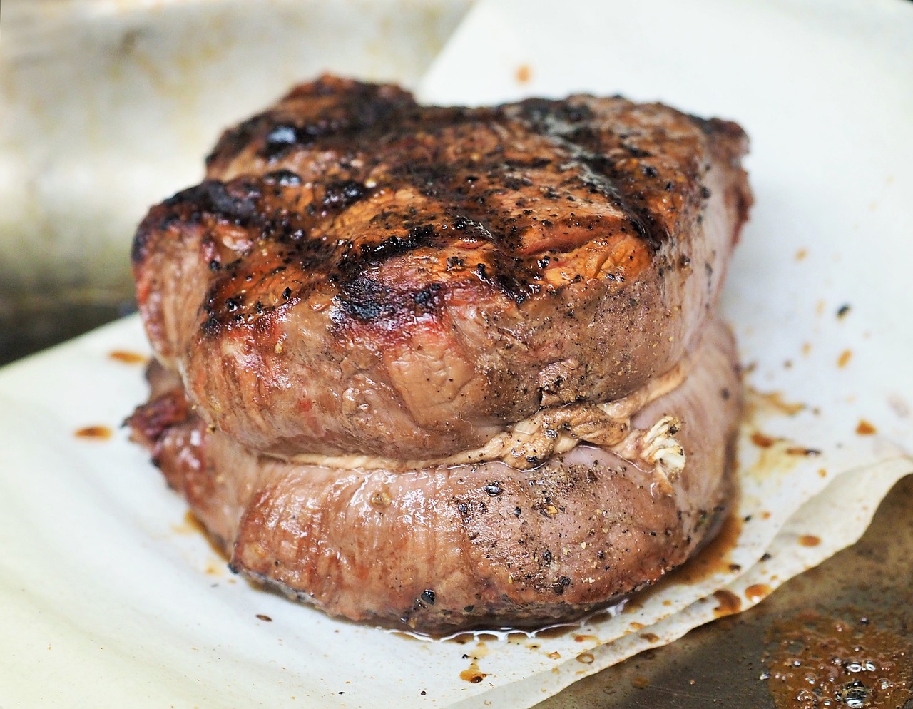 Someone eating  a medium cooked steak