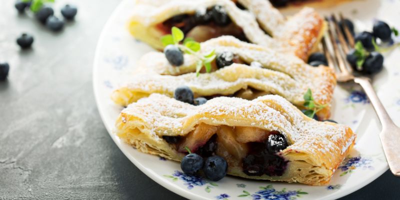 A plate of delicous-looking blueberry popovers garnished with fresh blueberries.