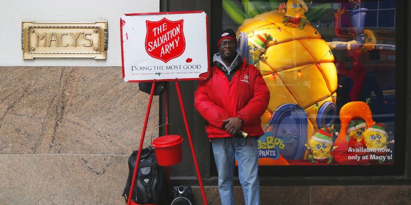 a salavation army volunteer in front of a retail store.