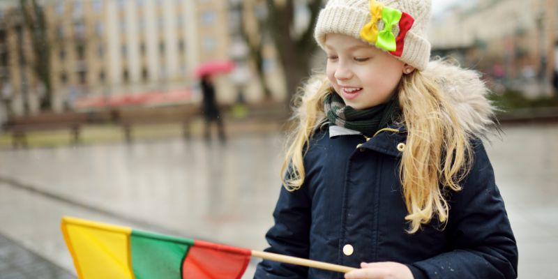 Happy child holding a Lithuanian flag