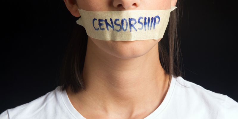 Woman With Word Censorship Written Across Tape on Mouth