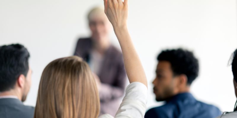 Someone raising their hand in a meeting or class