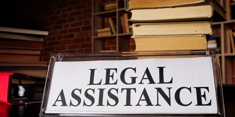 Legal assistance plate and pile of laws and papers.