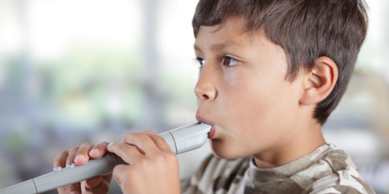 A young boy playing a recorder