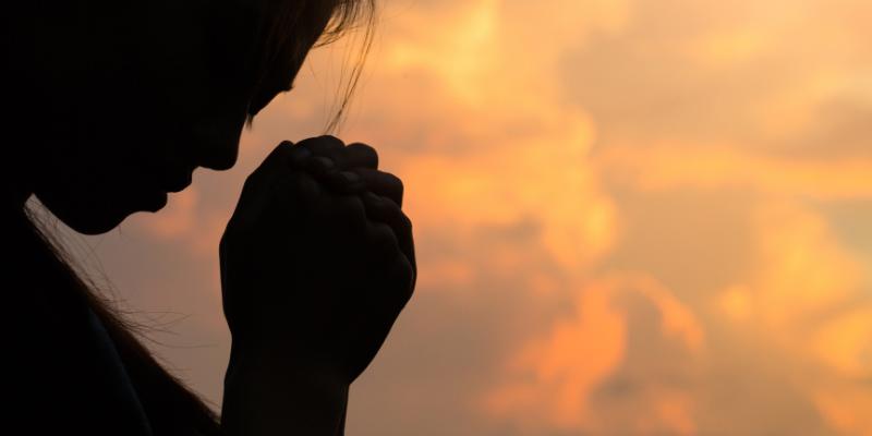 Silhouette of woman hands praying to god with the bible. Woman 