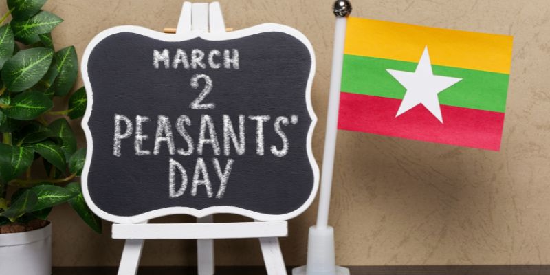 A badge with March 2 Peasants' Day on it next to a Myanmar flag.