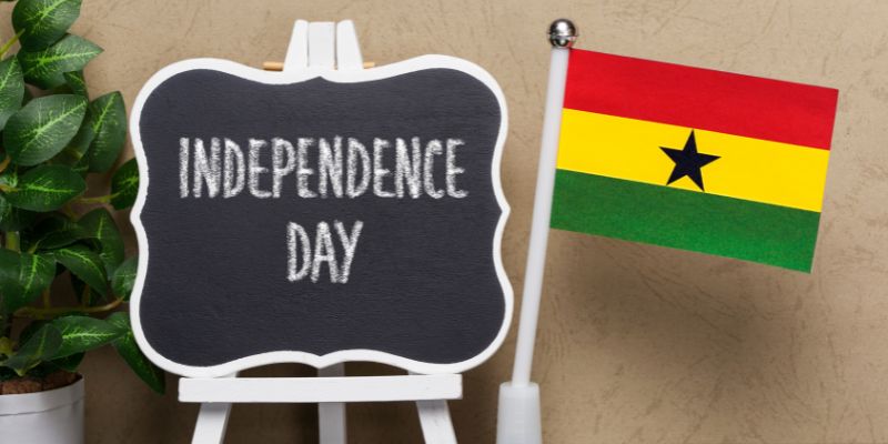 Independence day sign with a flag of ghana next to it.