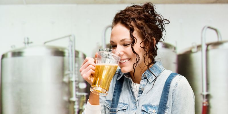 A woman brewing and tasting beer