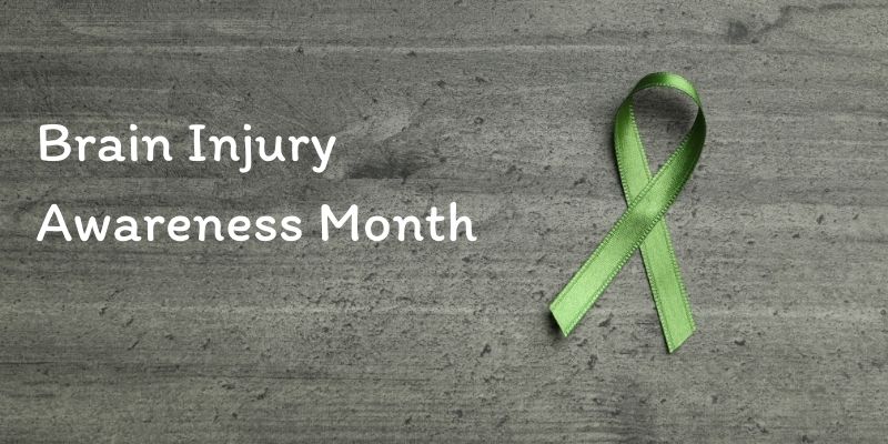 Brain injury awareness month sign with agreen ribbon.
