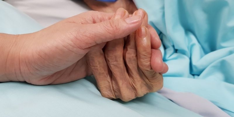 Someone holding a patient's hand