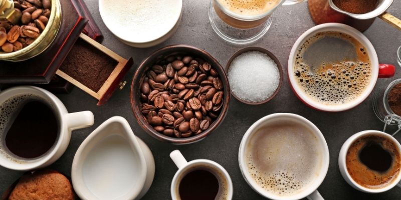 Cups filled with a variety of coffee, coffee beans, latte, milk