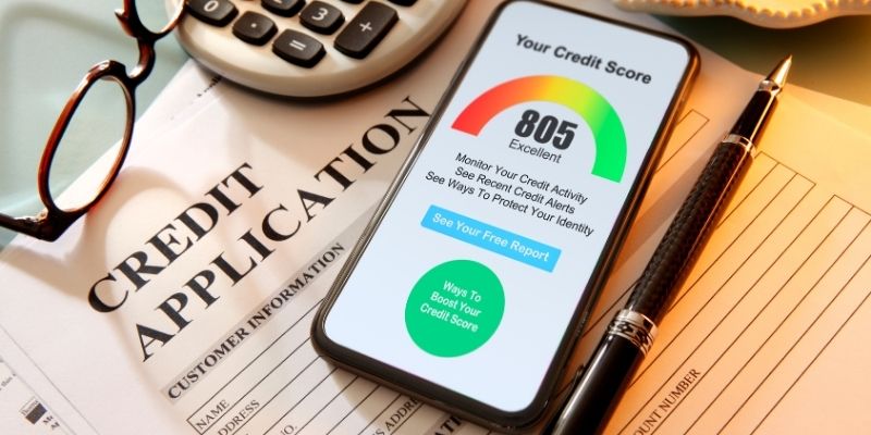 A credit application with a phone showing a credit score of 805