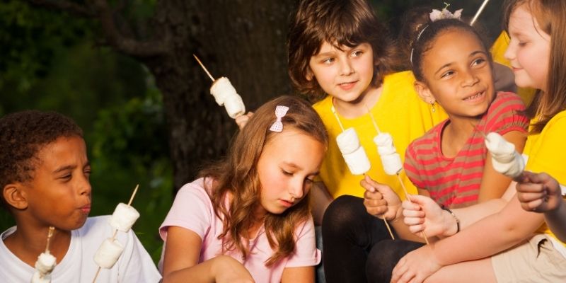 Kids around the campfire roasting marshmellows