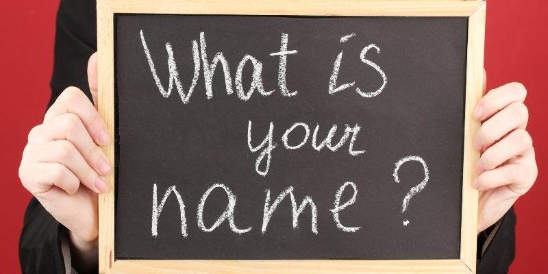 Someone holding up a sign that says "What is your name?"