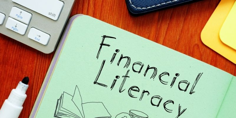 A desk with a notebook that reads Financial Literacy