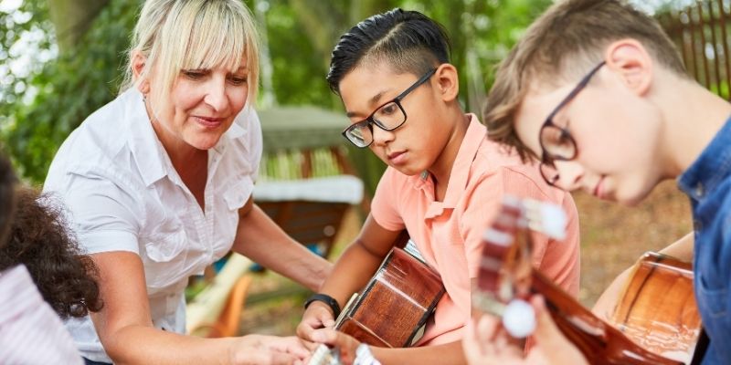 A music teacher giving a lessons to children.