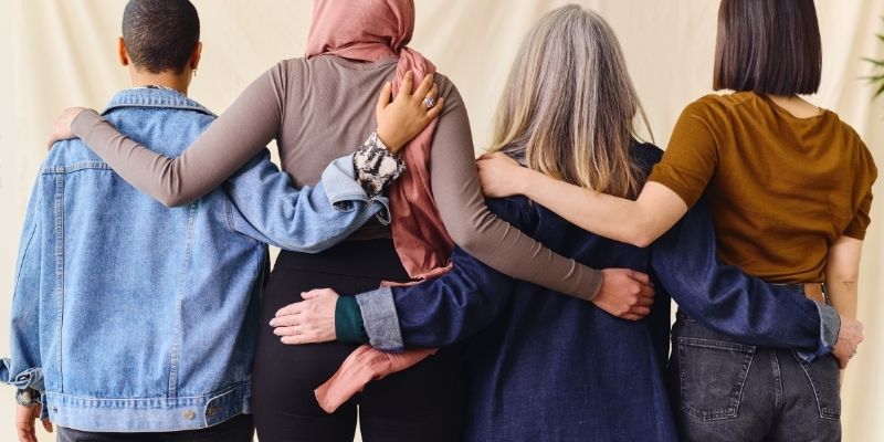 A group of women hugging with their backs to the camera.