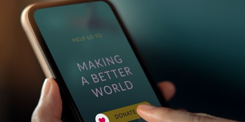 Someone with their cell phone that reads Making a Better World