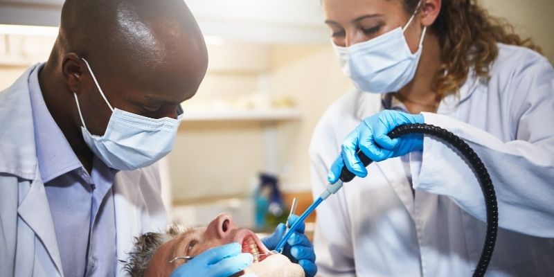 Dental assistant assisting the dentist with a patient