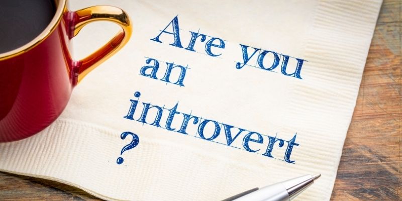 A cup of coffee on top of a paper that has the question "Are you an introvert?" on it.