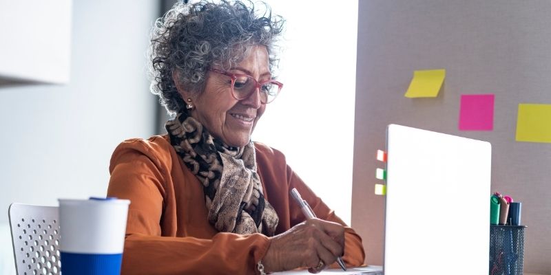 A mature worker typing on their laptop.