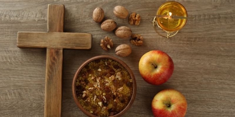 A cross, oil, bowl, fruits, and nuts