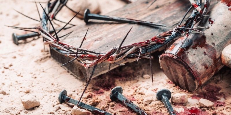Partial picture of a spiky crown and a crucifix
